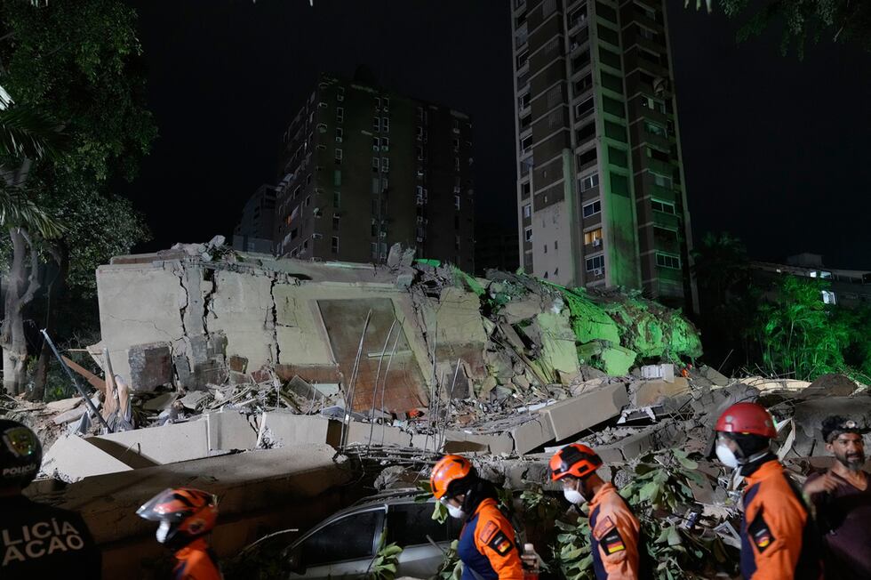 Trabajadores de rescate buscan entre los escombros de un edificio derruido tras un sismo, el...