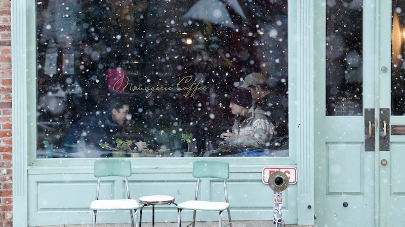 Clientes en el interior de una cafetería mientras nieva en el vecindario de Old City, en...