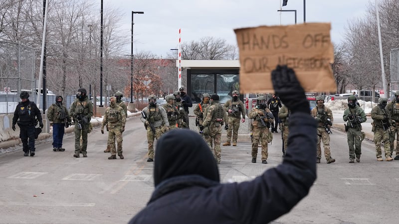 Protesters confront federal immigration officers outside the Bishop Henry Whipple Federal...