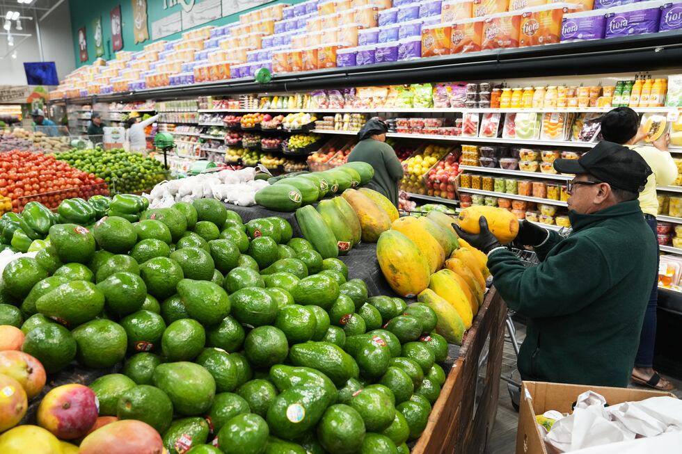 Un empleado coloca papayas en el supermercado Price Choice, que participa en el Programa de...